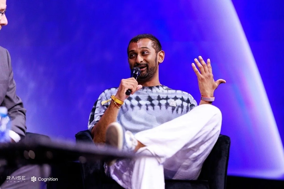 A SemiAnalysis analyst answering a question on a conference panel stage, mic in hand